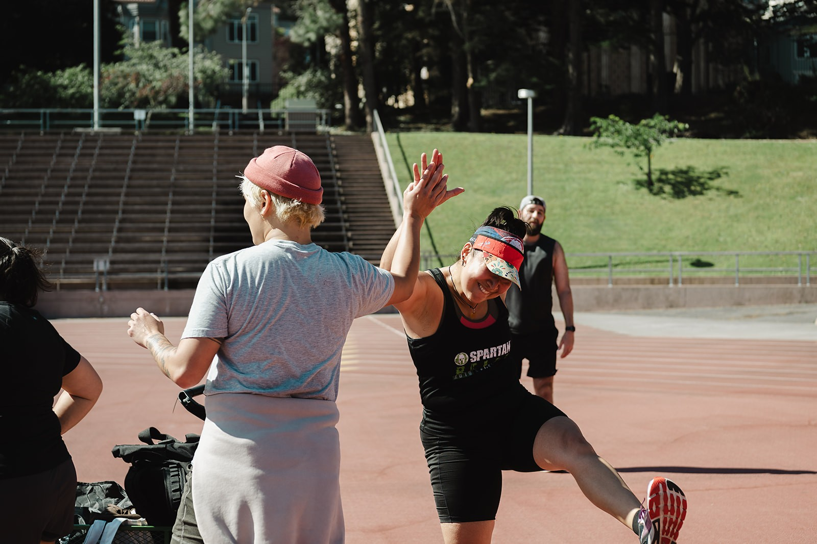 Coach high-fiving a member mid-workout at the track