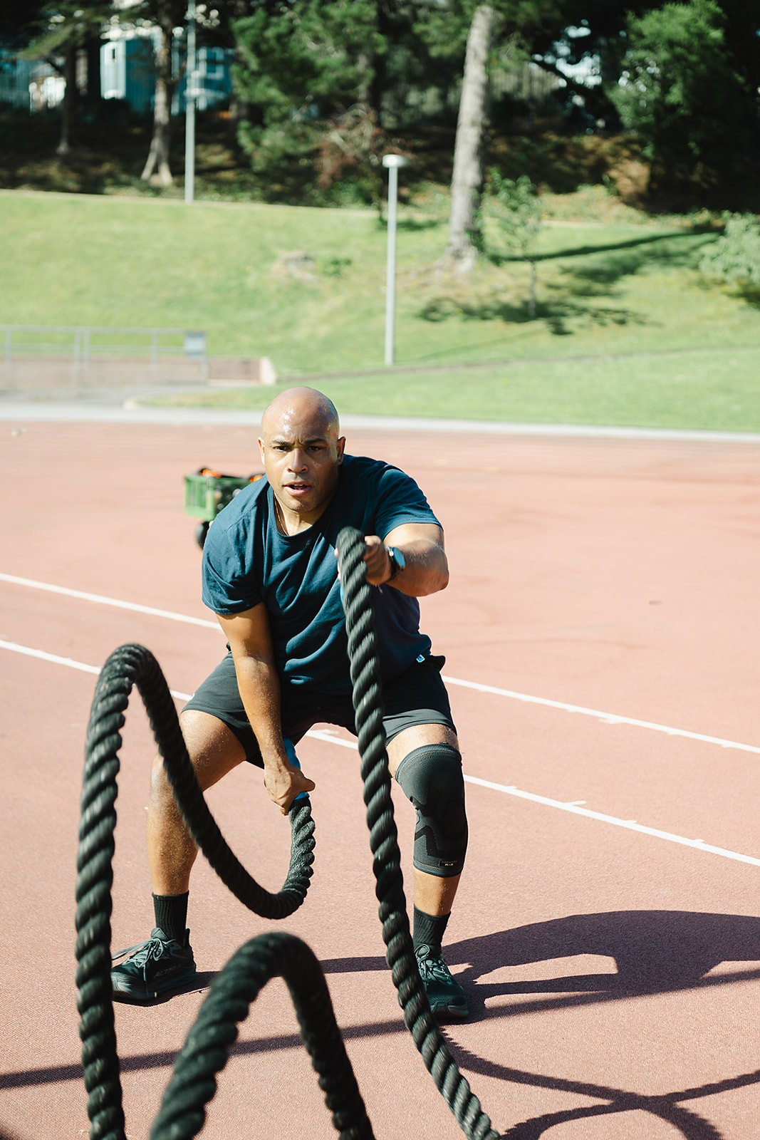Athlete working battle ropes on the outdoor track