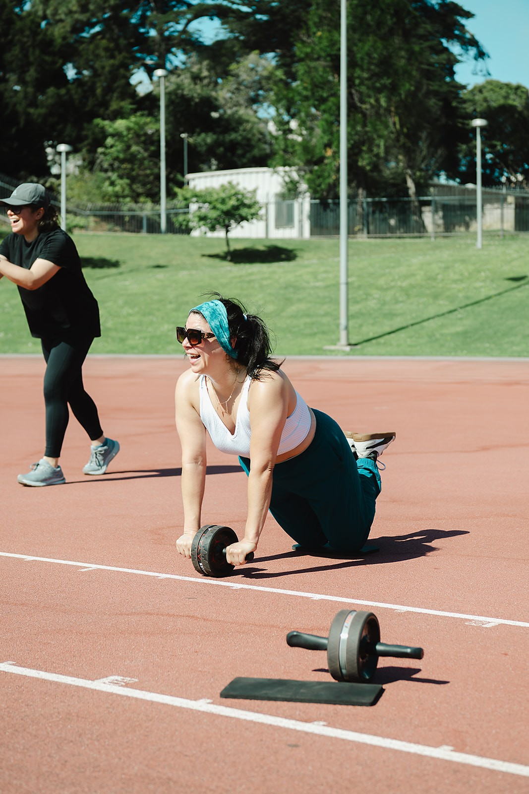 Member laughing through an ab wheel rollout on the track